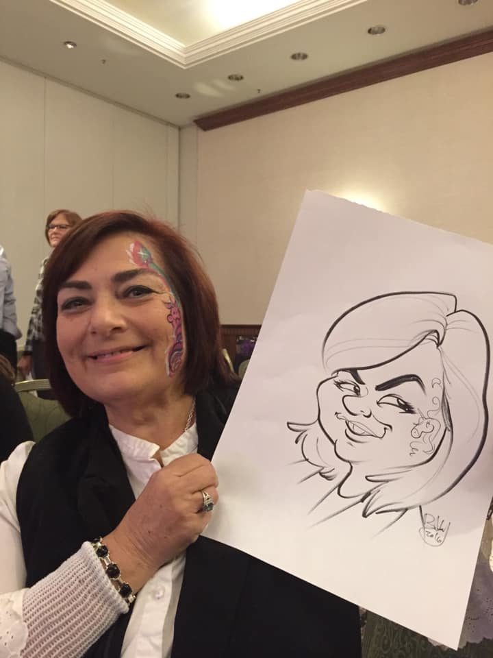 A woman with glanzmann's thrombasthenia holding up a drawing of a caricature.