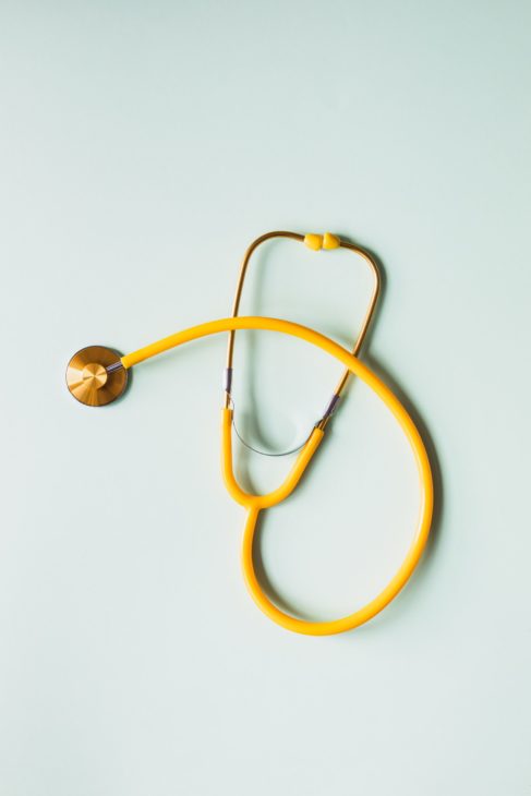 A yellow stethoscope on a blue background.