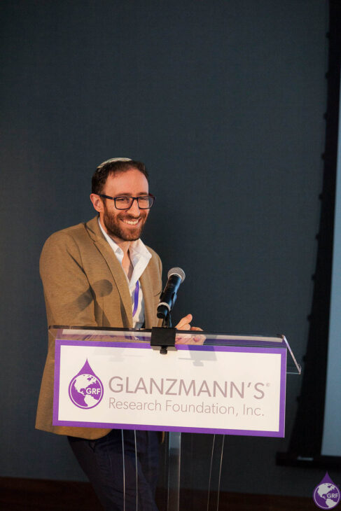 A man with glanzmann's thrombasthenia giving a speech at a podium.