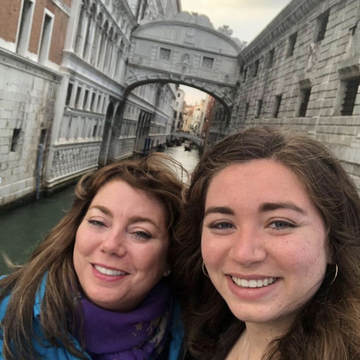 Two women posing for a photo in front of the sigh bridge in Venice, with Glanzmann's Thrombasthenia.